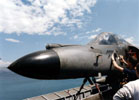 Mécanicien en train d'ajouter une silhouette de bombe à l'issue du retour d'un Super-Étendard après une mission de guerre. (©Marine Nationale)